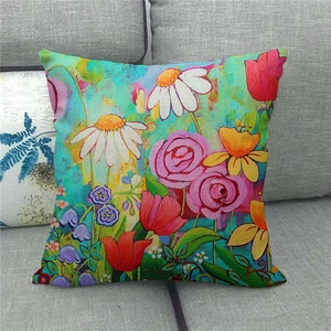 Detail of linen pillowcase with colorful floral oil painting on a gray fabric sofa