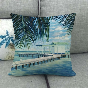 Detailed view of linen cushion cover featuring palm leaves and a coastal beach scene
