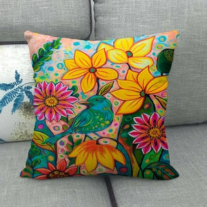 Artistic throw pillow with watercolor birds and flowers on a sofa, linen texture