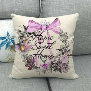 Linen decorative pillow cover with Home Sweet Home floral wreath print on a sofa