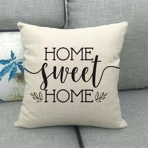 Detail of linen home sweet home pillowcase with floral design on a gray sofa