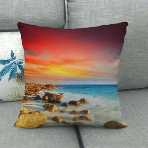 Detalle del estampado de atardecer en funda de cojín de lino sobre sofá gris