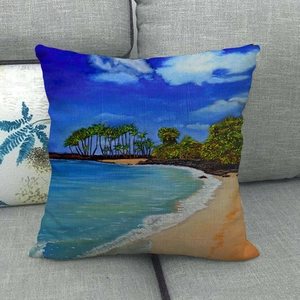 Detalle de la funda de cojín de lino con pintura de playa sobre un sofá gris