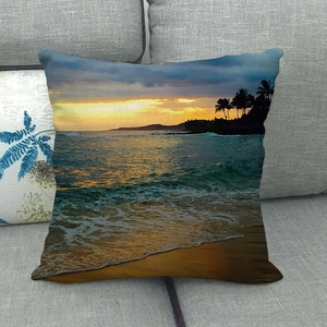 Detalle de la textura de funda de cojín de lino con playa y atardecer en sofá gris