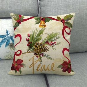 Détail de la housse de coussin en lin avec lettrage Peace, pommes de pin et houx
