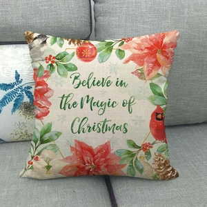 Détail de housse de coussin en lin avec oiseaux festifs, fleurs rouges et texte de Noël