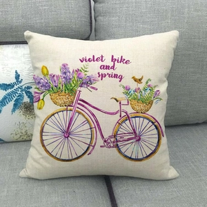 Detail of linen pillowcase with purple watercolor bike and flowers on a sofa