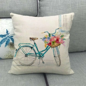 Detailed texture of linen pillowcase with watercolor floral bicycle print on a grey sofa