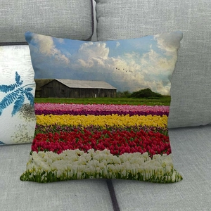 Detailed close-up of a linen pillowcase featuring a colorful oil painting tulip field scene