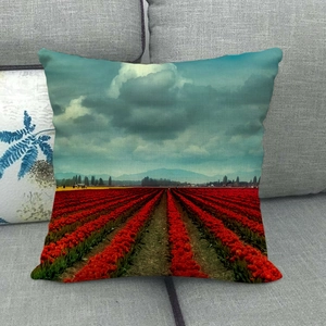 Linen throw pillow cover featuring a vibrant red tulip field and mountain landscape