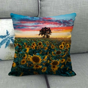 Close-up of linen cushion cover showing sunflower field sunset print on gray sofa
