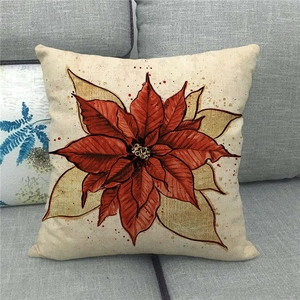 Detail view of linen Christmas pillowcase with artistic poinsettia floral print on sofa