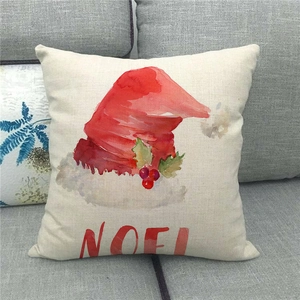 Christmas linen pillowcase with red watercolor Noel hat design on a cozy grey sofa
