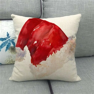 Detail of linen Christmas pillowcase featuring a watercolor red Santa hat design