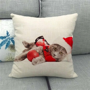 Close-up of linen pillow cover featuring a festive cat in a Santa hat and red outfit