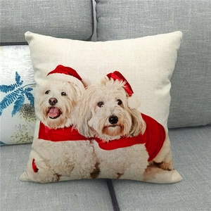 Christmas linen pillowcase featuring cute white dogs in festive hats on a grey sofa
