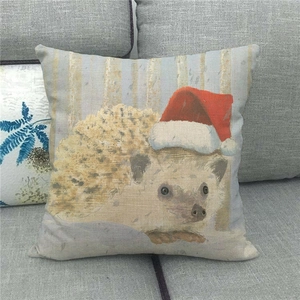 Detailed view of linen Christmas pillow cover with cute hedgehog wearing a red Santa hat