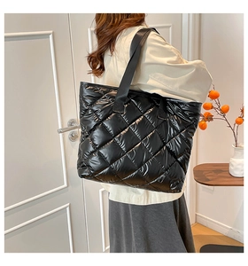 Détail d'un grand cabas matelassé noir avec motif à losanges et finition brillante