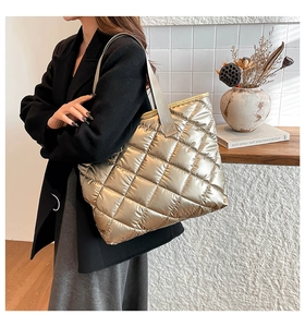 Gros plan détaillé d'un sac cabas matelassé doré avec texture métallique et bandoulière large