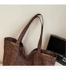 Close-up of leopard print tote bag fabric with reinforced handle and canvas texture