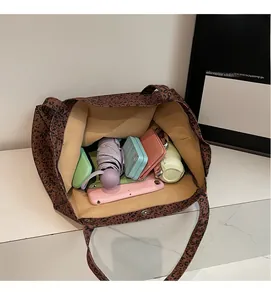 Spacious interior of leopard print tote bag holding iPad, umbrella, and daily essentials
