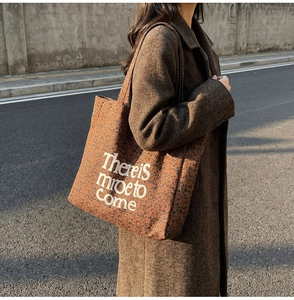 Close-up of vintage leopard print tote bag with white slogan and textured fabric