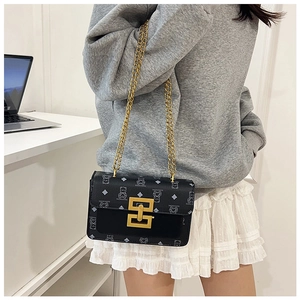 Détail du petit sac noir vintage avec chaîne dorée et motif monogramme d'oursons