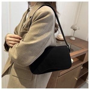 Detail of matte black underarm bag with silver buckle and adjustable shoulder strap