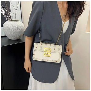 Détail du petit sac carré beige à motif d'ours avec bandoulière chaîne sur le mannequin