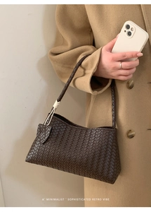 Détail de la texture en cuir tressé marron foncé avec pendentif nœud blanc