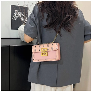 Détail du petit sac carré rose avec bandoulière en chaîne dorée et motif d'ours