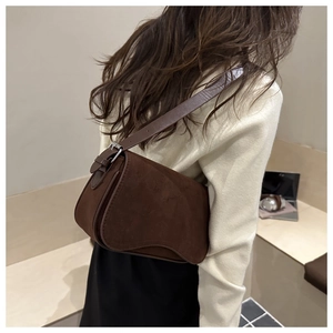 Side view of dark brown frosted suede shoulder bag with adjustable silver buckle strap