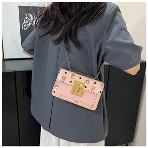 Détail du sac bandoulière rose avec imprimé ours, chaîne dorée et boucle métal
