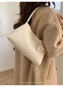 Détail du sac à main tissé blanc cassé montrant la texture tressée et le rabat latéral