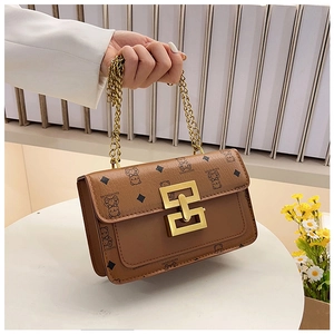 Détail d'un sac bandoulière marron avec imprimé ours, fermoir doré et bandoulière chaîne