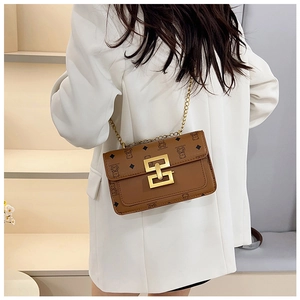 Détail du sac bandoulière vintage marron avec chaîne dorée et fermoir magnétique