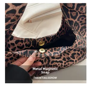 Detailed view of the leopard print bag featuring a secure golden magnetic snap closure