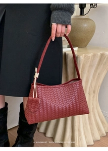 Detailed view of the woven texture on a dark red retro style leather underarm shoulder bag