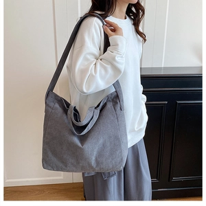 Dettaglio della borsa tote in velluto a coste blu-grigio con trama fine e design capiente