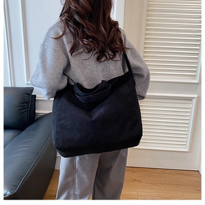 Texture dettagliata della borsa tote in velluto a coste nero con grande capacità e righe