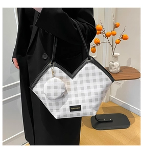 Detail of checkered tote bag with V-shaped opening and matching round coin purse