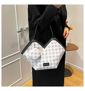 Detail of checkered tote bag with V-shaped opening and matching round coin purse charm