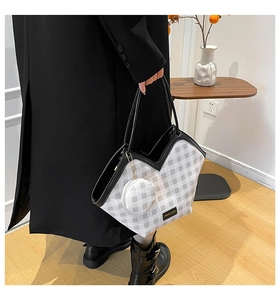 Detail of checkered tote bag with V-shaped cut and matching round coin purse charm