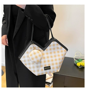 Detail of yellow checkered canvas tote bag with a matching round coin purse and logo tag