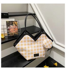 Detail of yellow checkered bucket bag with V-cut top and matching mini pouch charm