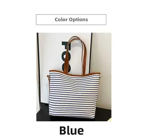 Close-up detail of blue and white striped tote bag with premium brown leather handles