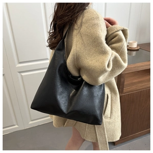 Detail of vintage pleated texture on a large black minimalist shoulder tote bag