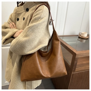 Detail view of large brown faux leather hobo tote bag with a soft wrinkled texture
