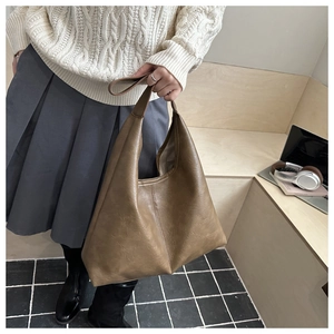 Detailed view of large brown faux leather tote bag for daily commute and work