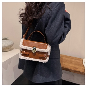 Detailed back view of a brown leather crossbody bag with white faux fur trim and gold lock